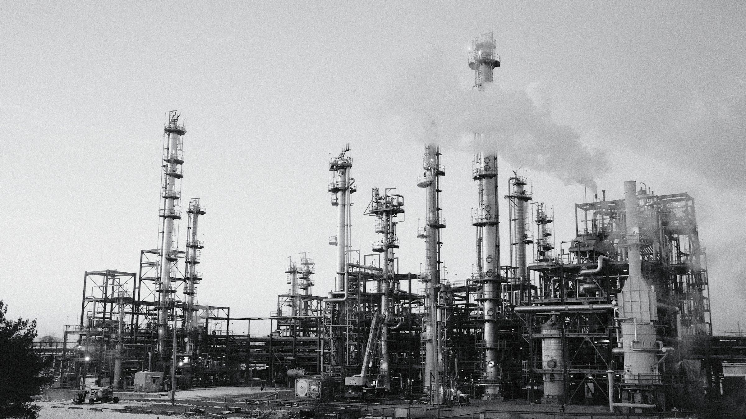 Black and white photograph of a refinery with process columns and stacks